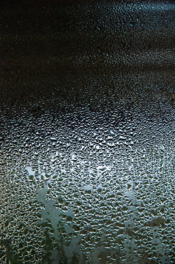 Water drops on a glass, with reflections on a dark background. Water drops on a glass, with reflections on a dark background