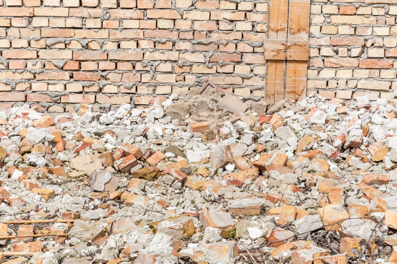 Remains of hurricane or earthquake disaster total damage on ruined old house or building with pile of bricks