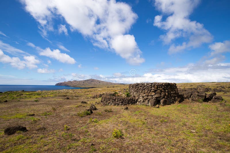 Remains of stone structures along the northern coast of Easter Island with the Poike volcano in the background, Easter Island