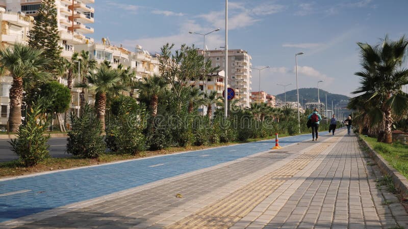 Remblai le jour d'été. quai avec piste cyclable et promenade piétonne. gens marchant le long de joli front de mer