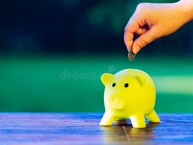 Remettez insérer une pièce de monnaie dans la tirelire verte - l'épargne Co d'écologie image stock