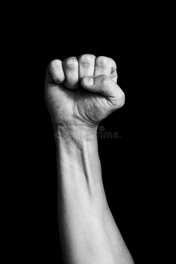 Remettez montrer le poing de poing d'un homme élevé sur un fond noir image libre de droits Remettez montrer le poing de poing d'un homme élevé sur un fond noir image libre de droits