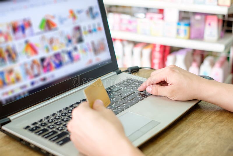 Remettez tenir la carte de crédit et employer l'onlin d'achats de paiement d'ordinateur portable photographie stock Remettez tenir la carte de crédit et employer l'onlin d'achats de paiement d'ordinateur portable photographie stock