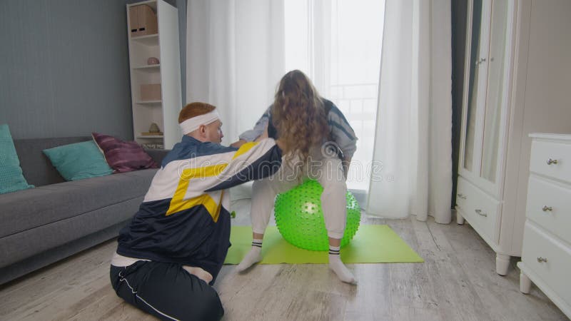 Remise en forme de la famille à la maison. Jeune femme et homme heureux de couples de formation ensemble à la maison banque de vidéos