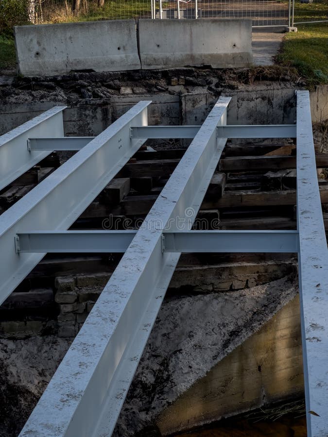 Remont małego starego mostu. dźwigary stalowe malowane i w dobrym stanie leżące na zgniatanych i zgniatanych podkładach drewnianyc zdjęcia stock