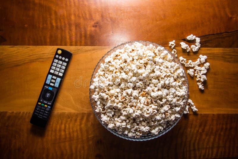 Remote Control and a Bowl of Popcorn on the Wooden Table. Stock Image