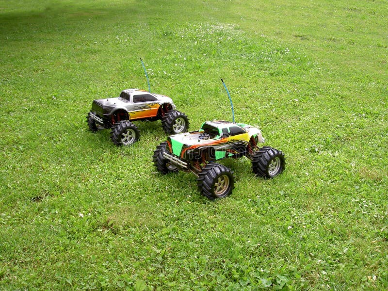 Remotecontrolled Models of Offroad Cars Standing in a Meadow Overgrown with Grass Stock Image