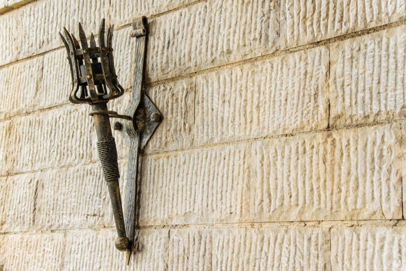 Removable iron torch on a medieval castle stone wall.