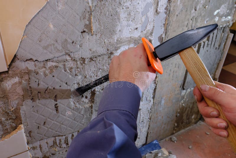 Removing Old Tiles from the Wall in the Kitchen Using a Chisel with a