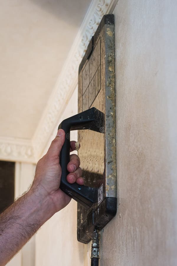 Removing the Old Wallpaper of the Wall by Using a Steam Device Stock