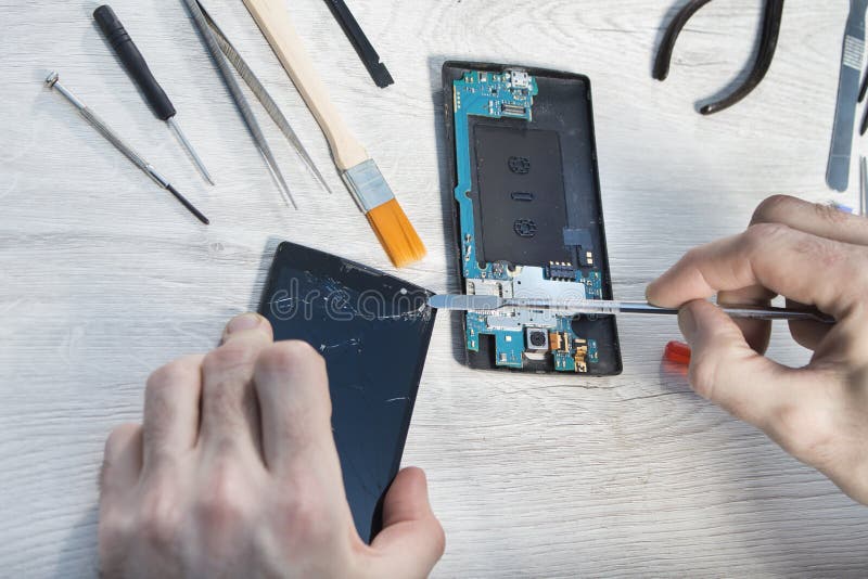 Remplacement du verre cassé à un téléphone portable dans un service de téléphone portable photographie stock libre de droits Remplacement du verre cassé à un téléphone portable dans un service de téléphone portable photographie stock libre de droits