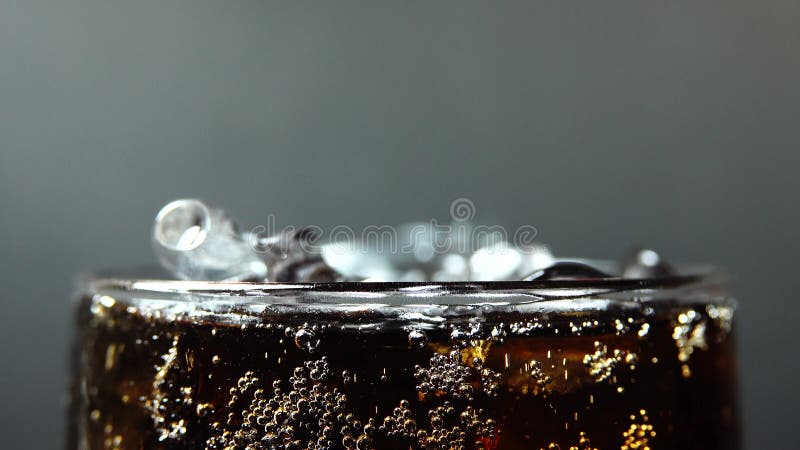 Remplissage 4k vers le haut d'une tasse de fin vers le haut de la macro tir des bulles dans des gouttes de coca de l'eau dans le g banque de vidéos