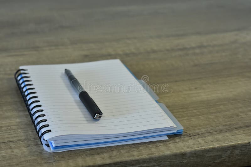 Ren notepad med en penna på ett träskrivbord arkivbilder Ren notepad med en penna på ett träskrivbord arkivbilder