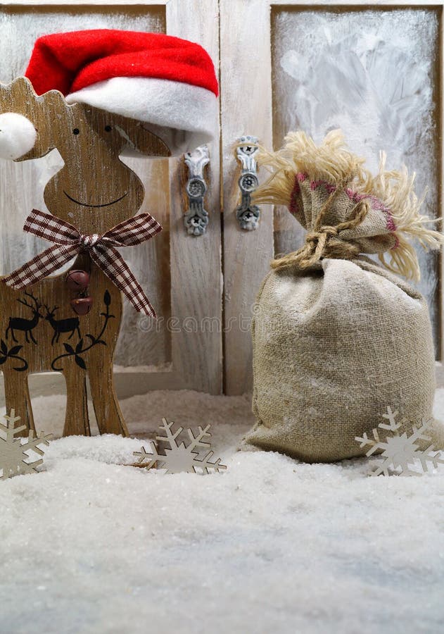 Ren in Sankt-Hut und eine Tasche von Weihnachtsgeschenken stockbild Ren in Sankt-Hut und eine Tasche von Weihnachtsgeschenken stockbild