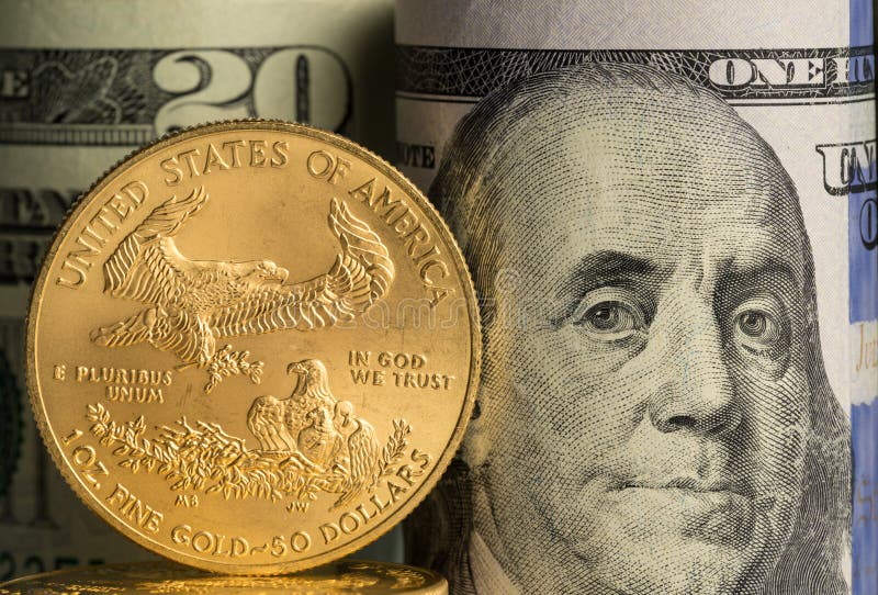 Rena guld- mynt framme av bankrullar av USA-valuta royaltyfri bild