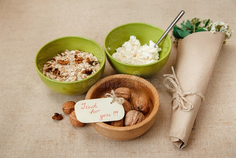 Table Appointments for Healthy Organic Breakfast.Walnuts,Oatmeal and Cottage Cheese.Green Ceramic and Wooden Plates.Wish Card with Bouquet. Table Appointments for Healthy Organic Breakfast.Walnuts,Oatmeal and Cottage Cheese.Green Ceramic and Wooden Plates.Wish Card with Bouquet.