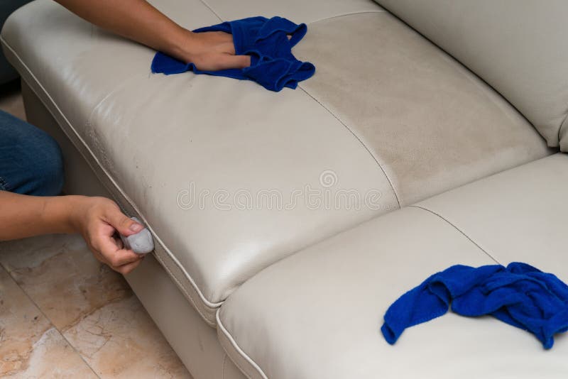 Rengörande lädersoffa med svampen och handduken arkivfoto
