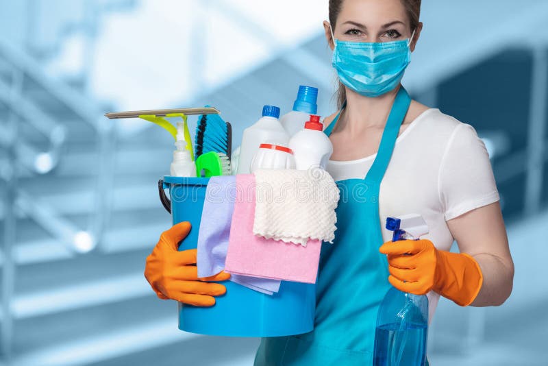 Cleaning lady with tool in cleaning in mask on a blurred background. Cleaning lady with tool in cleaning in mask on a blurred background