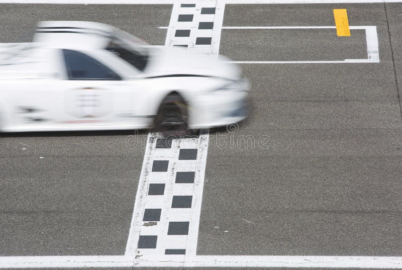 Race car crossing the finishline on the straight strech of a circuit on the grid. Race car crossing the finishline on the straight strech of a circuit on the grid