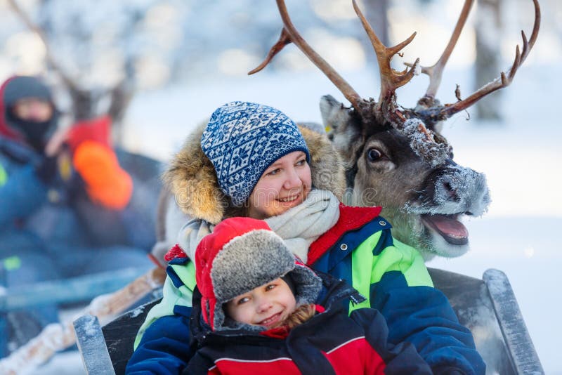 Family of mother and little girl at reindeer safari in winter forest in Lapland Finland. Family of mother and little girl at reindeer safari in winter forest in Lapland Finland