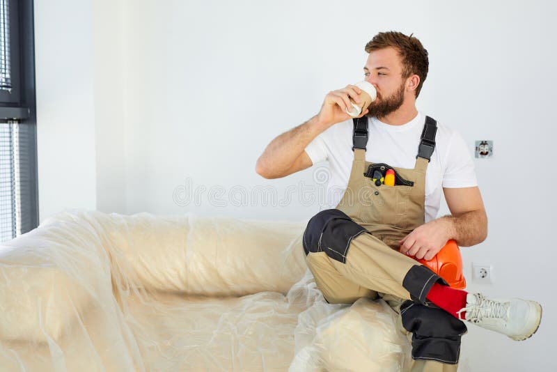 Repair concept. man worker or builder is drinking coffee after work, have rest stock images