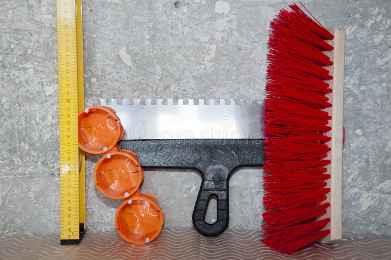 Repair and construction. repair tool set. putty knife, brush broom, bushings for sockets and building level. socket box with spatula and measuring balance level, fetlock on damaged wall background