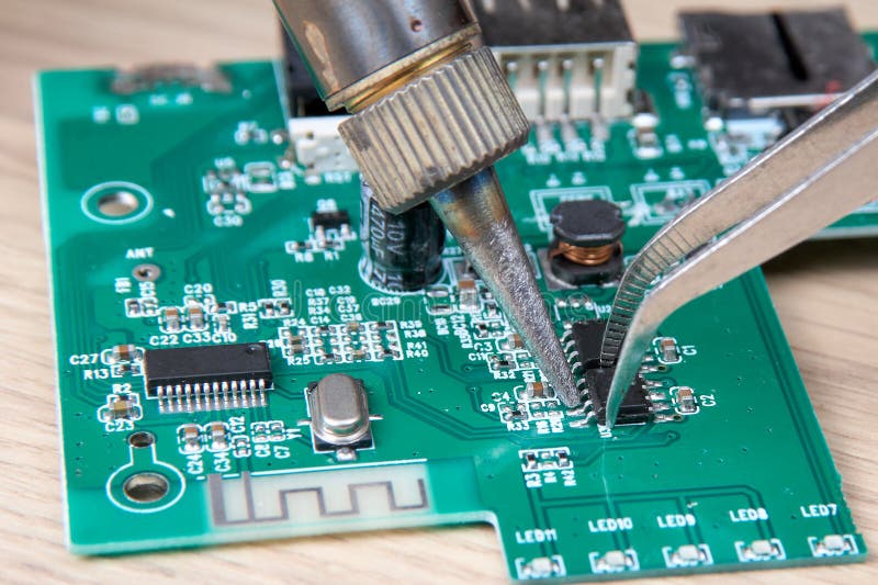 Repair of an Electronic Board by Replacing a Damaged Part with a Soldering Iron Stock Photo