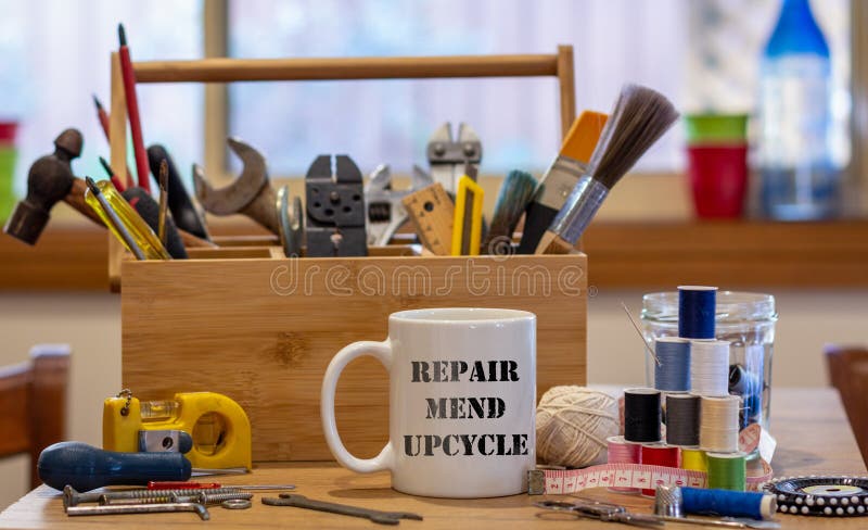 Repair Mend upcycle on a mug surrounded by repair tools, consumer activism to repair