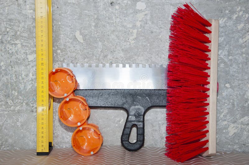 Repair tool set. putty knife, brush broom, bushings for sockets and building level. socket box with spatula and measuring balance level, fetlock on damaged wall background. repair and construction