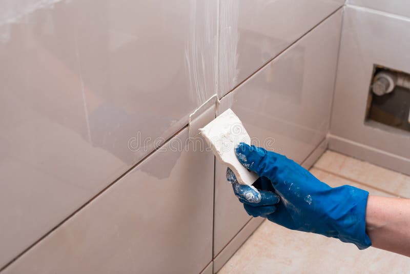 Repair and Wall Cladding with Tiles. the Master Rubbing the Tile Joints
