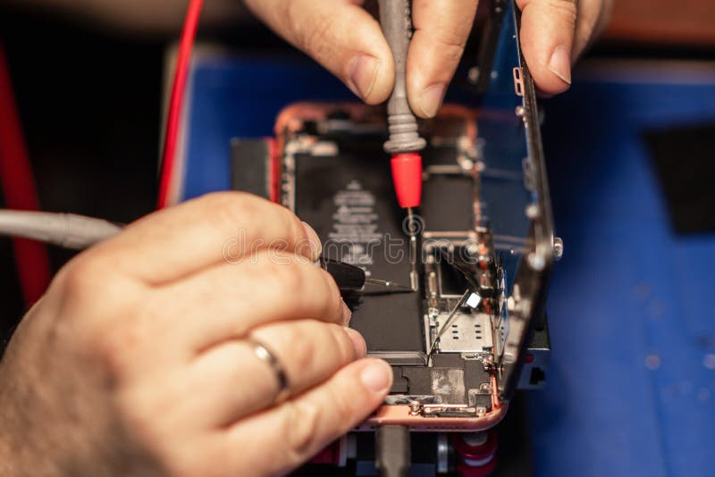 Repairing a smartphone battery with precision tools to ensure optimal performance during a busy afternoon at a tech royalty free stock images