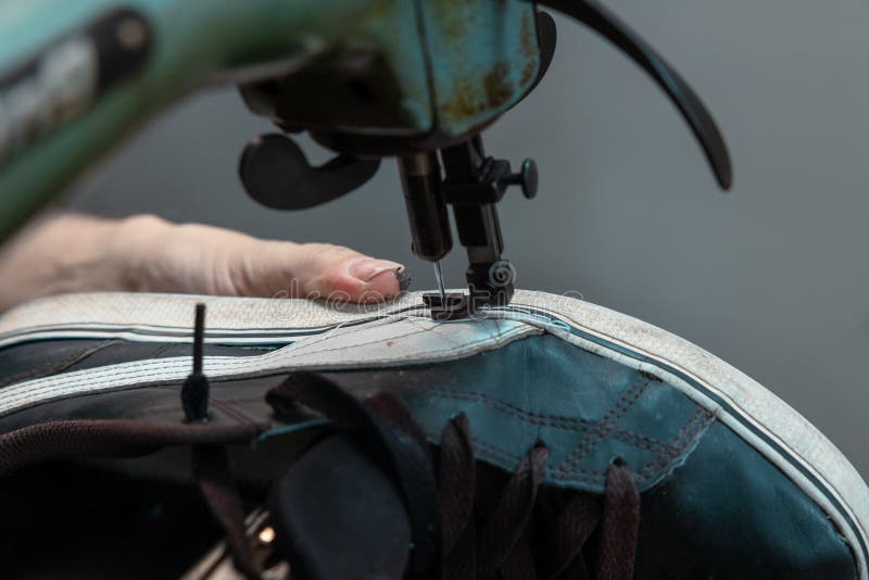 Repairing Sneakers. Man Repairing a Sneaker by Using a Sewing Machine Stock Photo Image of