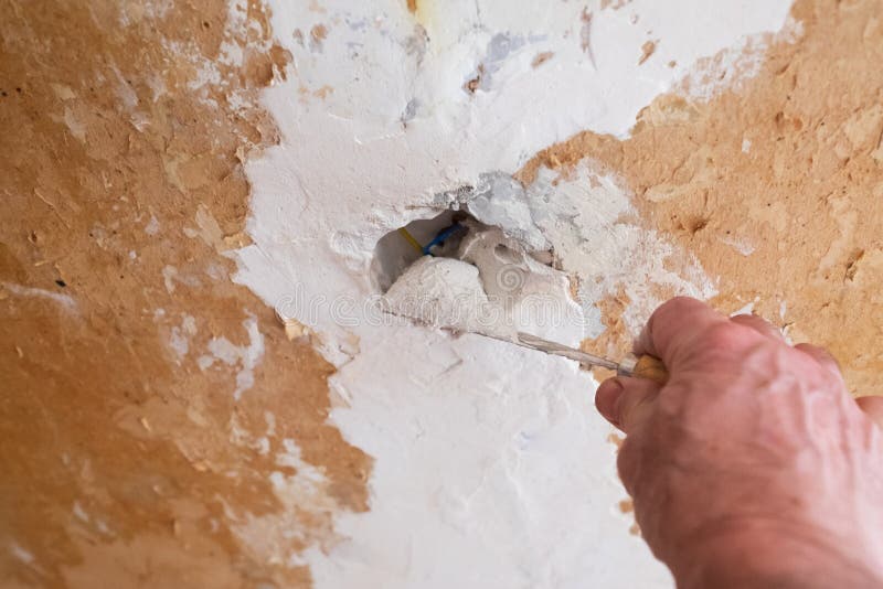 Repairing the Wall Man Putting Spackle on a Hole in the Wall Stock