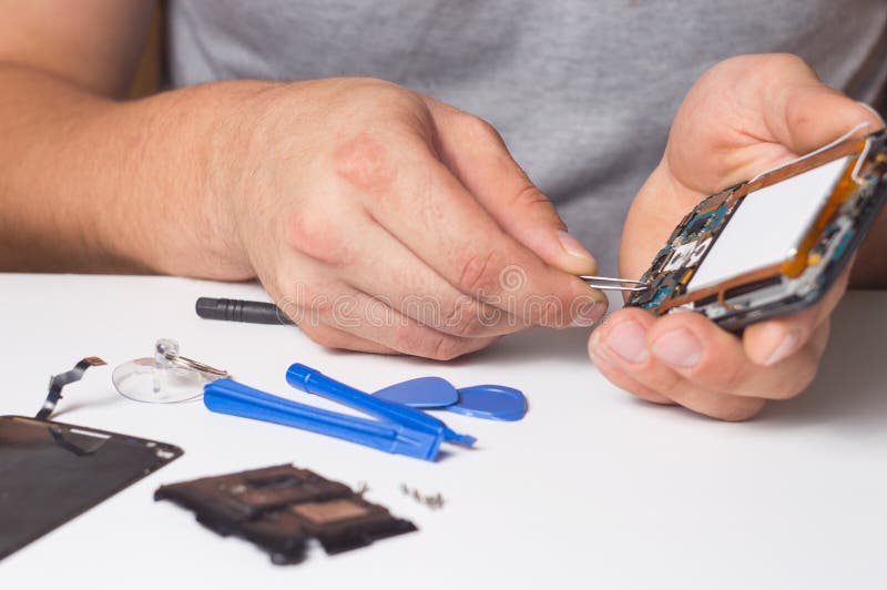 Repairman fixing disassembled smartphone with special tools and screwdrivers. concept of electronics repair devices stock images Repairman fixing disassembled smartphone with special tools and screwdrivers. concept of electronics repair devices stock images