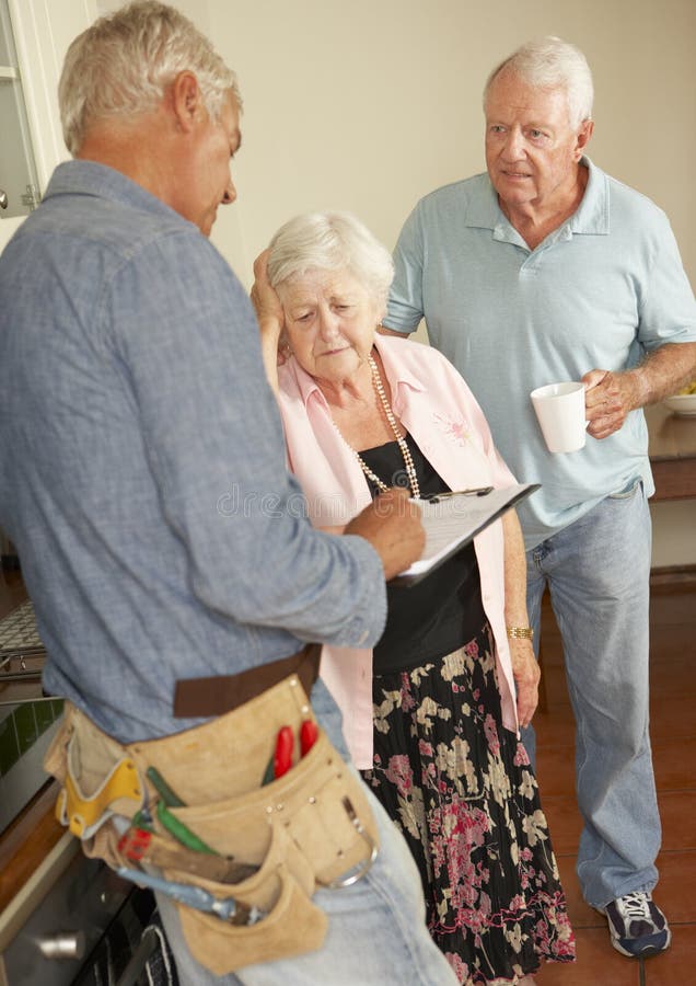 Repairman Giving Senior Couple Estimate For Repair stock images Repairman Giving Senior Couple Estimate For Repair stock images