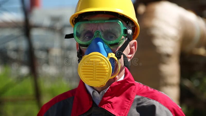 Repairman in hard hat, goggles and respirator at industrial area