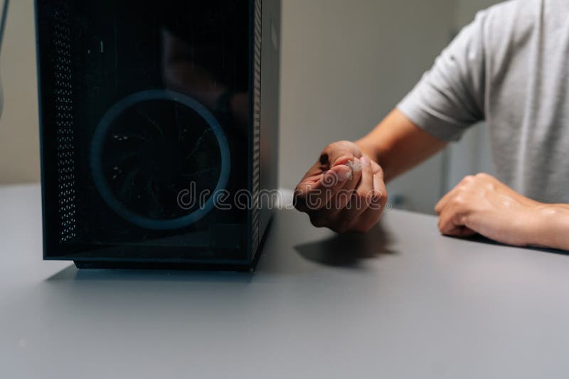 Repairman holding dust clump removed from computer case, highlighting importance of routine cleaning for maintaining stock images