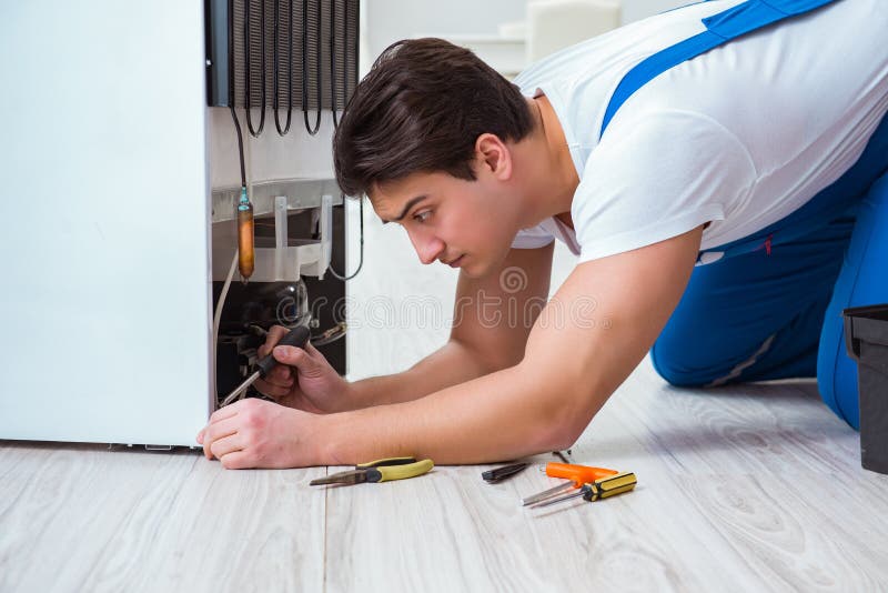 Repairman kontrahenta naprawiania fridge w diy pojęciu obraz royalty free Repairman kontrahenta naprawiania fridge w diy pojęciu obraz royalty free