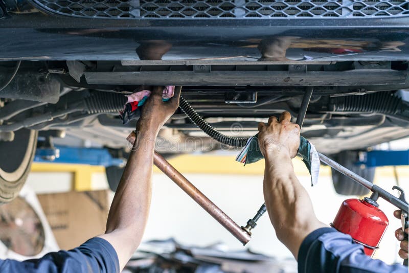 Repairman or mechanic during use inject gun flush oil for cleaning in inside cooling tube for modify or development cooling system of automobile gasoline or diesel engine at garage.