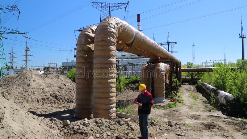 Repairman near heating main pipeline at heat station