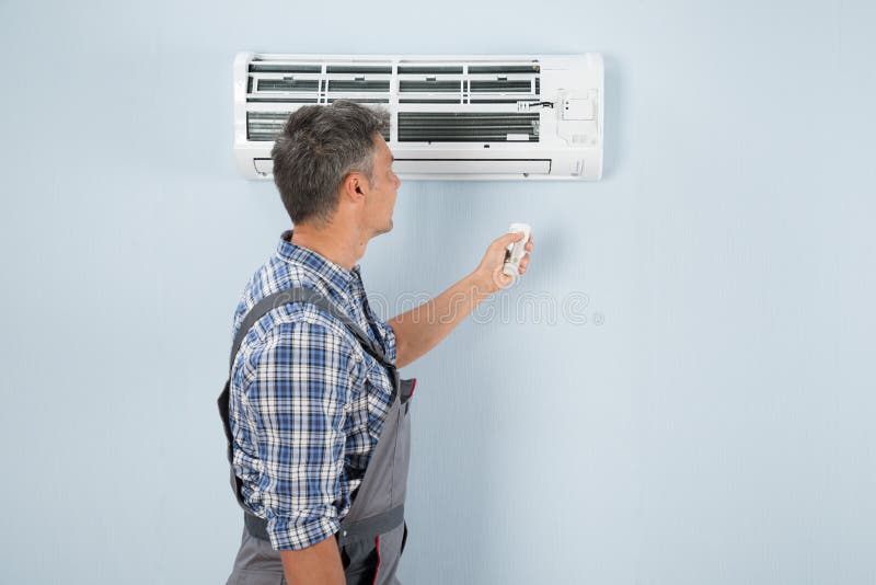 تقديرات لتطلب تقدير تكييف الهواء الخاص بك Repairman-operating-air-conditioner-remote-controller-close-up-technician-54964774