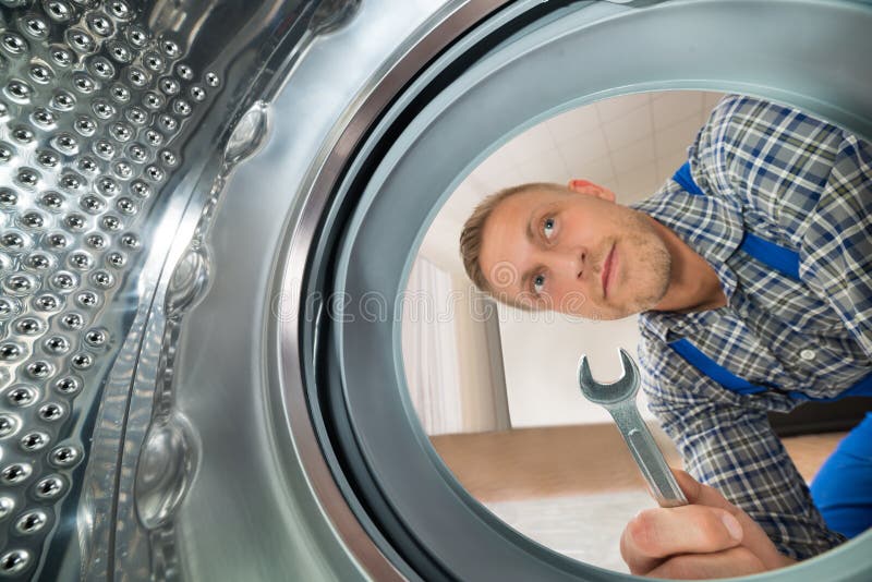 Repairman Patrzeje Wśrodku pralki zdjęcie stock