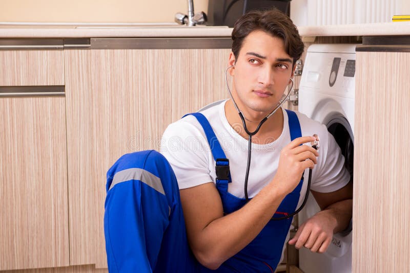 The Repairman Repairing Washing Machine at Kitchen Stock Photo Image