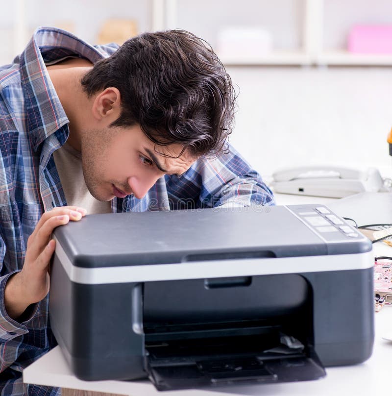 The hardware repairman repairing broken printer fax machine. The hardware repairman repairing broken printer fax machine