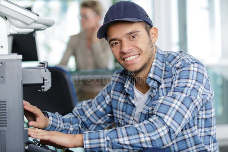 hardware repairman repairing broken printer fax machine smiling. hardware repairman repairing broken printer fax machine smiling