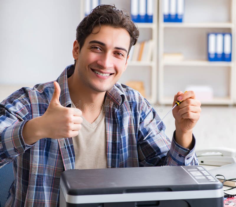 The hardware repairman repairing broken printer fax machine. The hardware repairman repairing broken printer fax machine