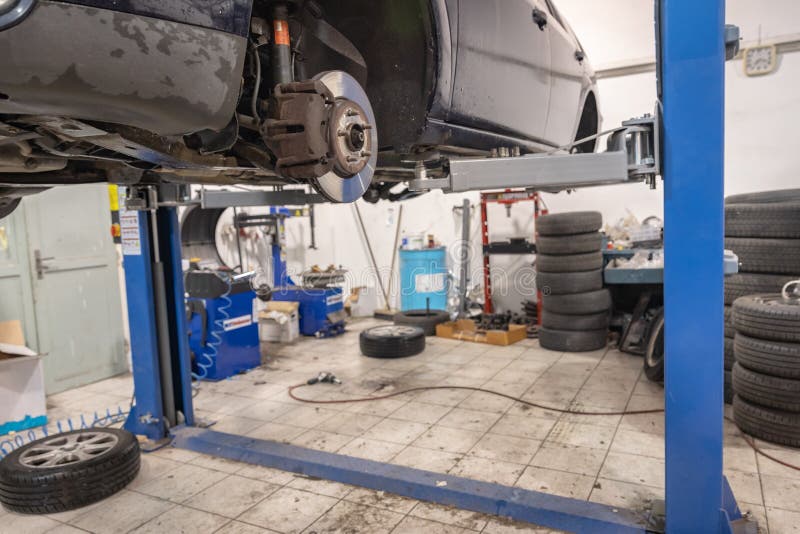 Reparatie en controleauto in reparatiewerkplaats Een ervaren technicus herstelt het defecte deel van de auto Ik verander banden stock foto Reparatie en controleauto in reparatiewerkplaats Een ervaren technicus herstelt het defecte deel van de auto Ik verander banden stock foto
