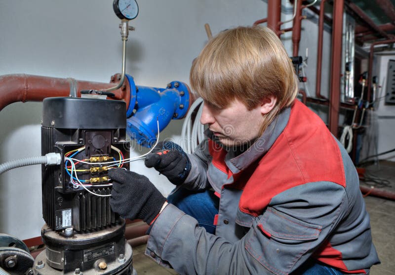 Repare el sistema de calefacción de la bomba, mecánico conecta los alambres con eléctrico imágenes de archivo libres de regalías Repare el sistema de calefacción de la bomba, mecánico conecta los alambres con eléctrico imágenes de archivo libres de regalías