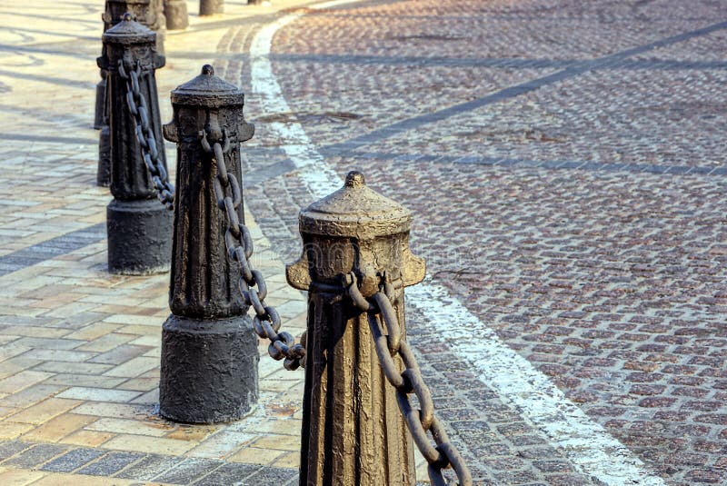 Repassez les vieux piliers avec la chaîne sur le trottoir près de la route image libre de droits Repassez les vieux piliers avec la chaîne sur le trottoir près de la route image libre de droits
