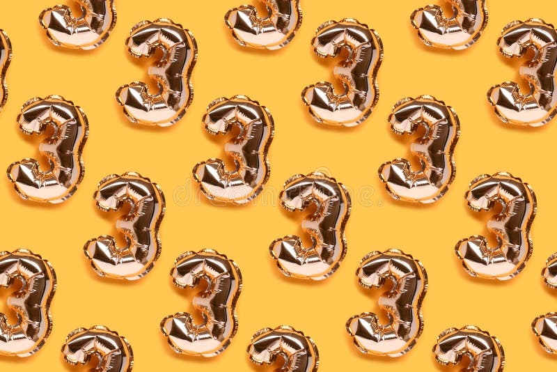 Repetitive pattern made of number three golden balloons. stock image
